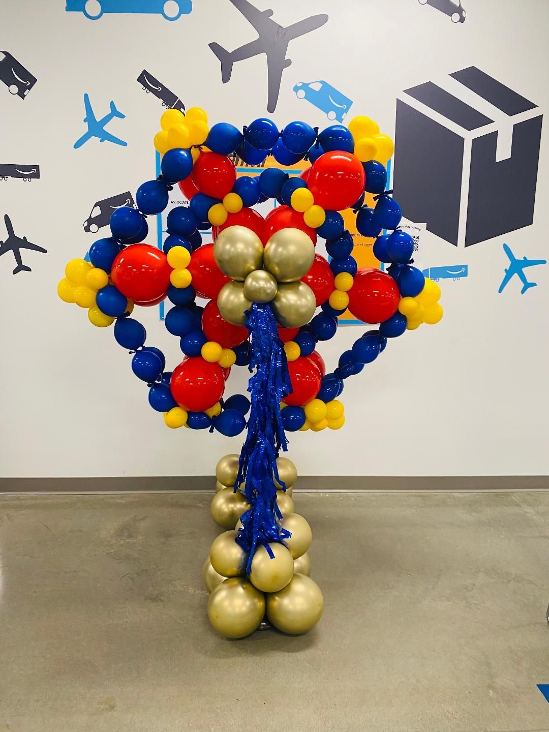 Colorful balloon sculpture resembling a tree or bouquet in an indoor setting