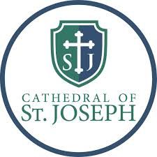 Cathedral of St. Joseph logo with green shield and white cross inside a blue circle