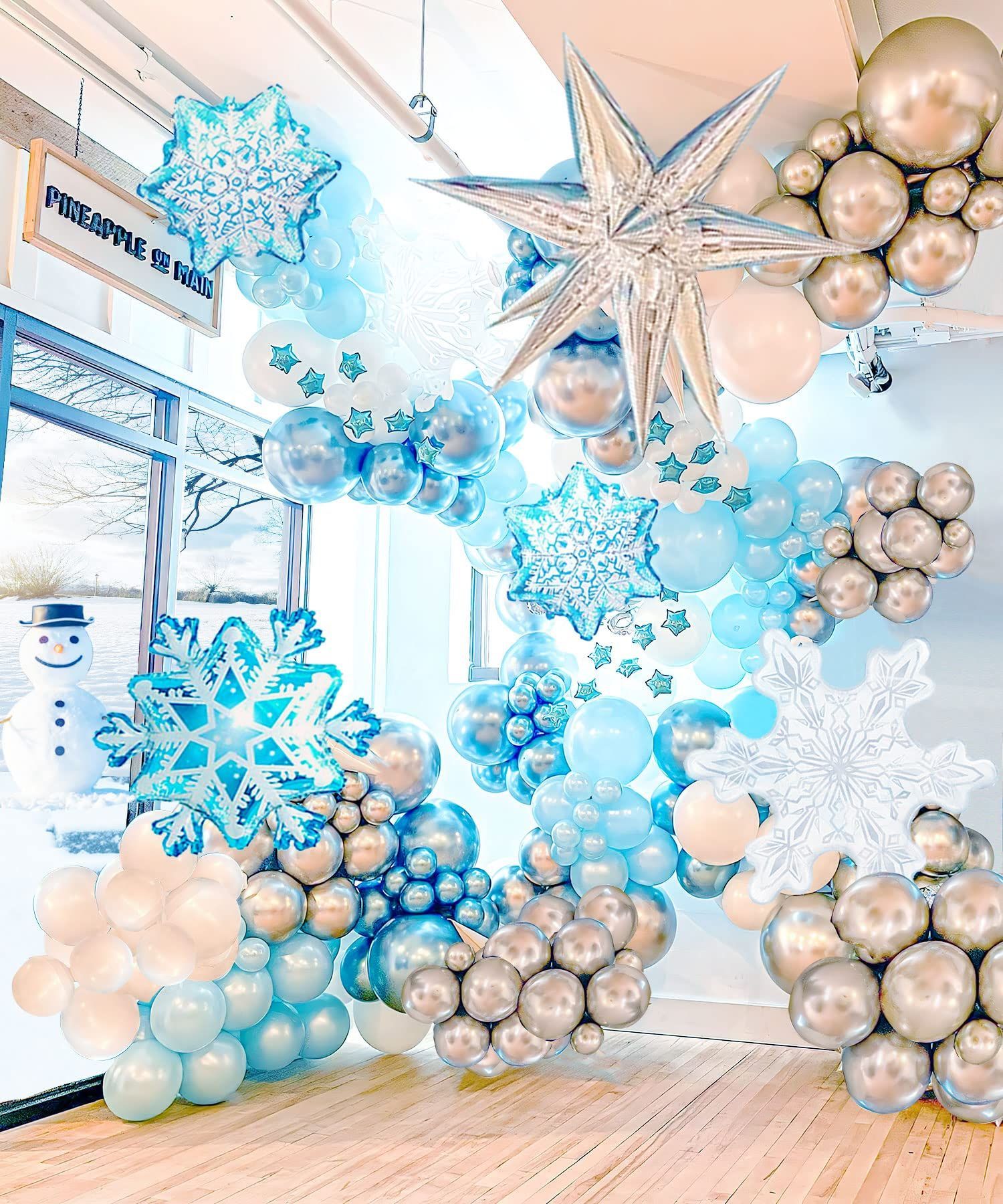 Blue and silver balloon arch with snowflakes decorating a bright indoor entrance