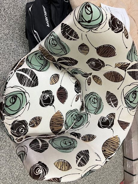 Patterned white scarf with mint green and black circular designs folded on a gray surface