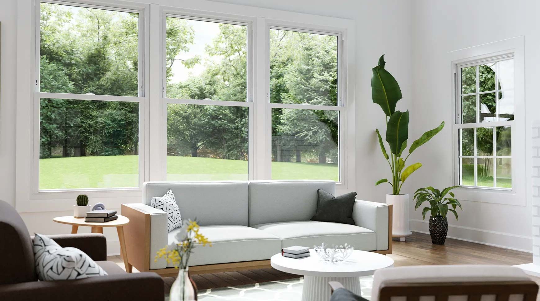Living room with large windows overlooking a green yard, white walls, and light-colored furniture.