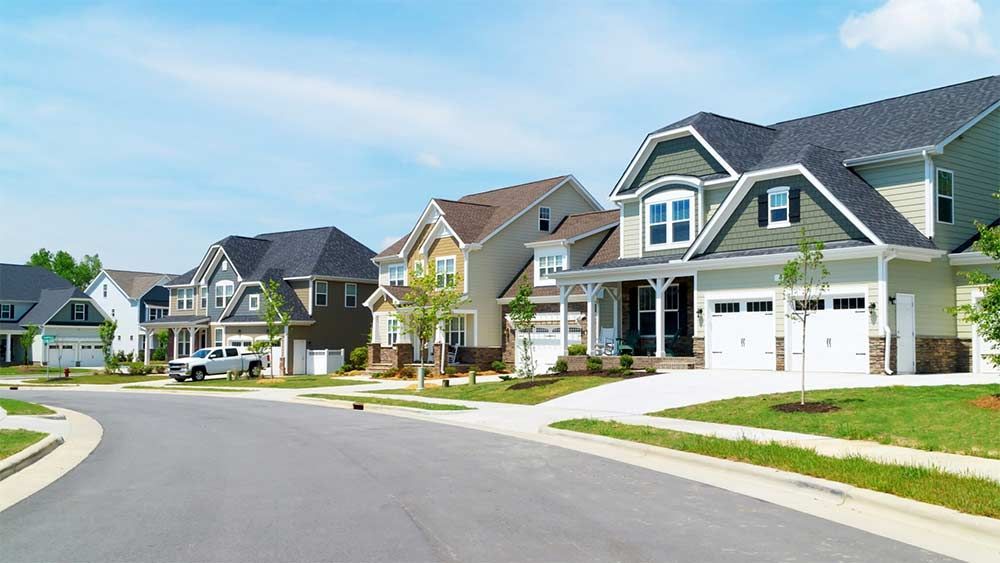 Suburban street with houses; blue sky, sunny day.