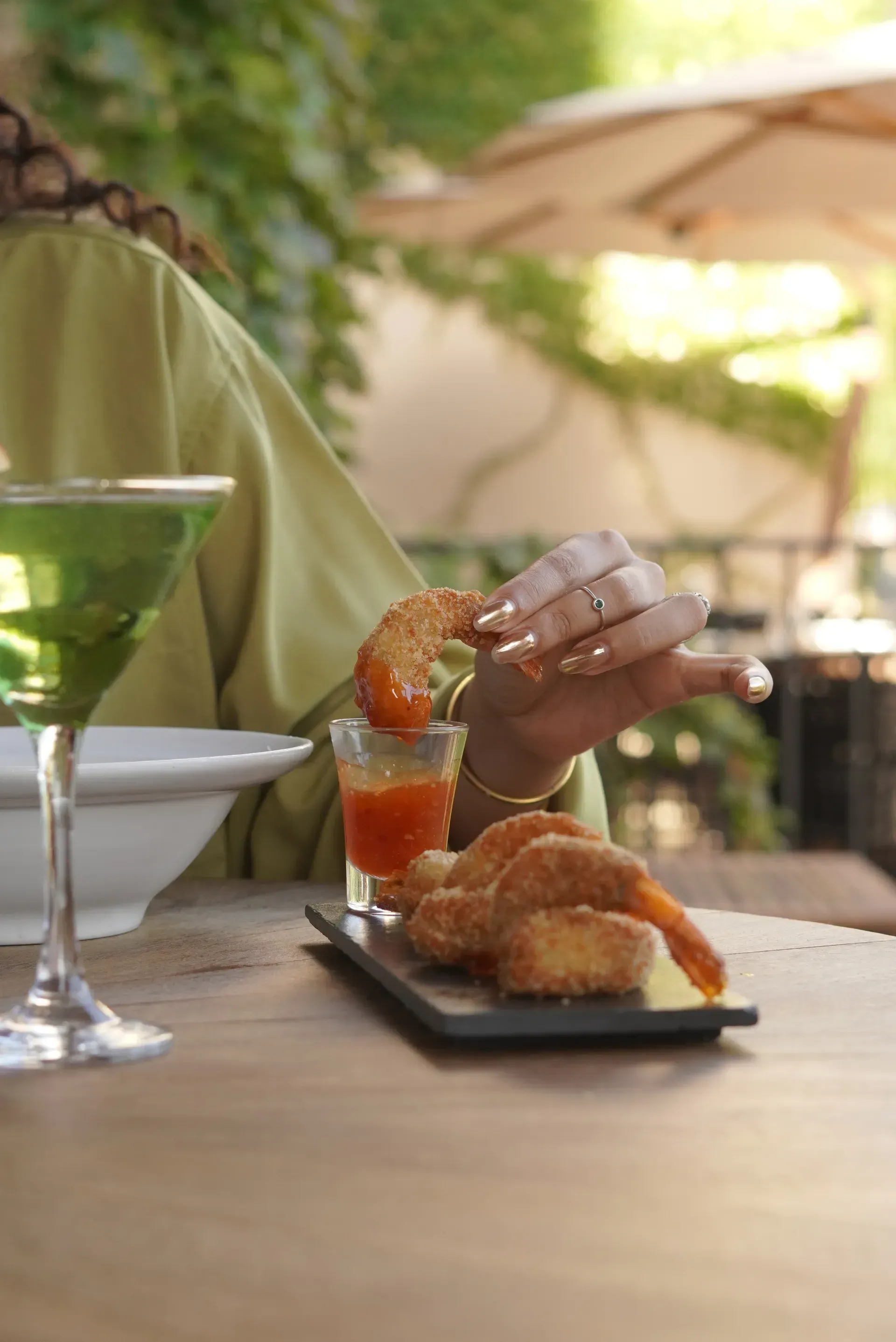 Café da manhã servido em uma mesa na varanda, com café, doces, frutas e suco de laranja.