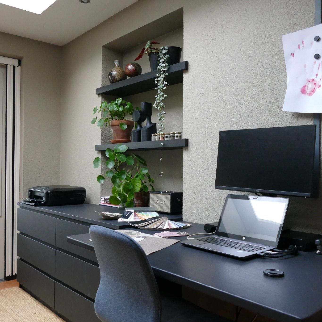 Een relax kantoor met al di schappen met decoratieve objecten, donkere elementen Bureau kantoor Maasbree