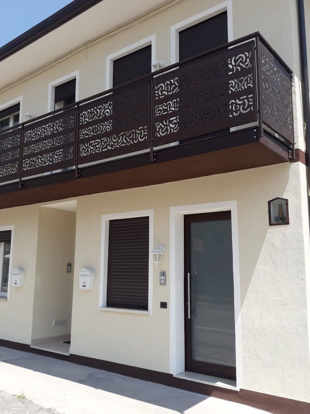una casa bianca con un balcone e una porta