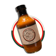 Amber bottle with a black cap and circular label, tilted over a red and green ring on a white background