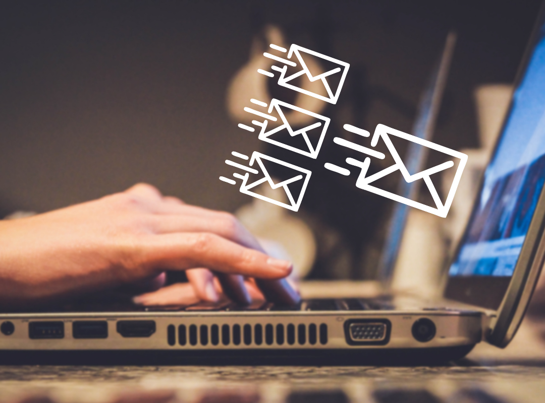 A person is typing on a laptop computer with envelope icons coming out of the screen.