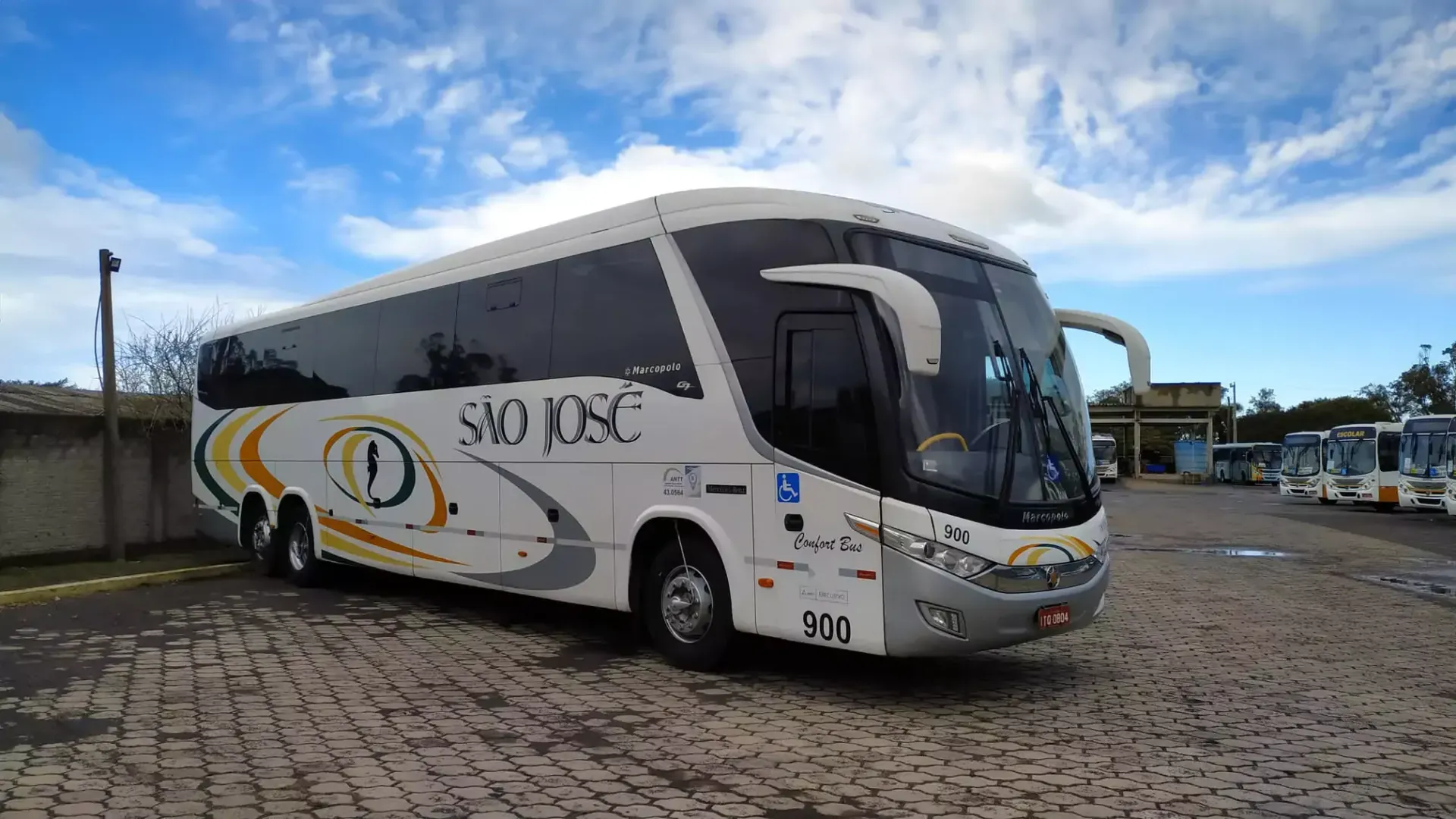 Ônibus branco da Expresso São José estacionado em um estacionamento.
