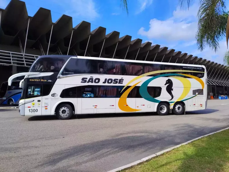 Um ônibus branco da Expresso São José na lateral, estacionado na rodoviária.
