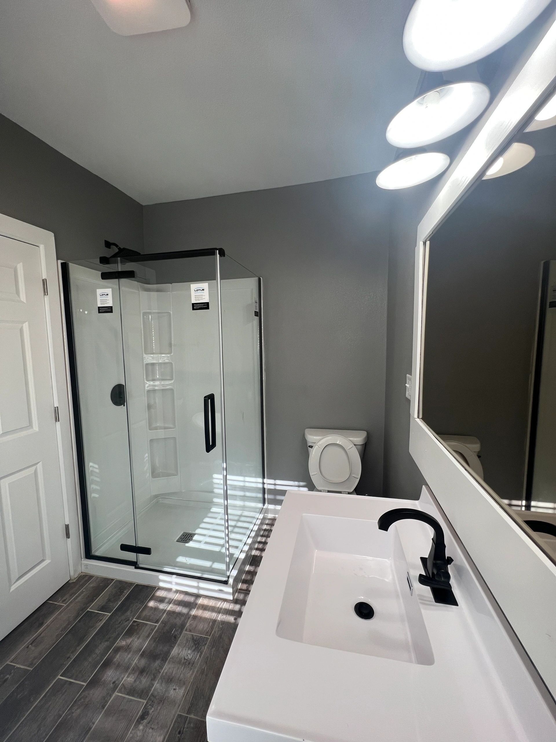 A bathroom with a toilet a sink and a mirror