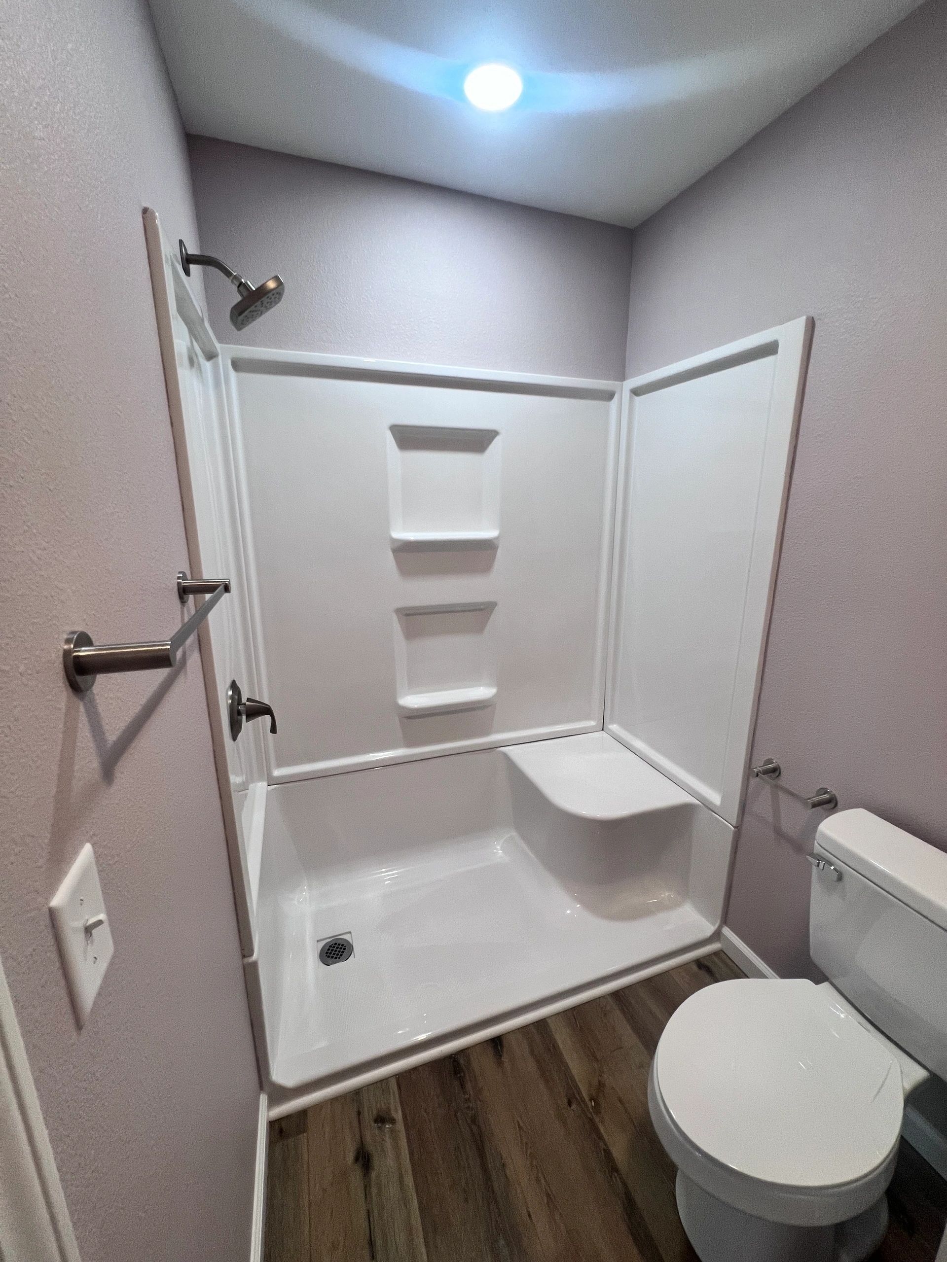 A bathroom with a toilet and a shower stall