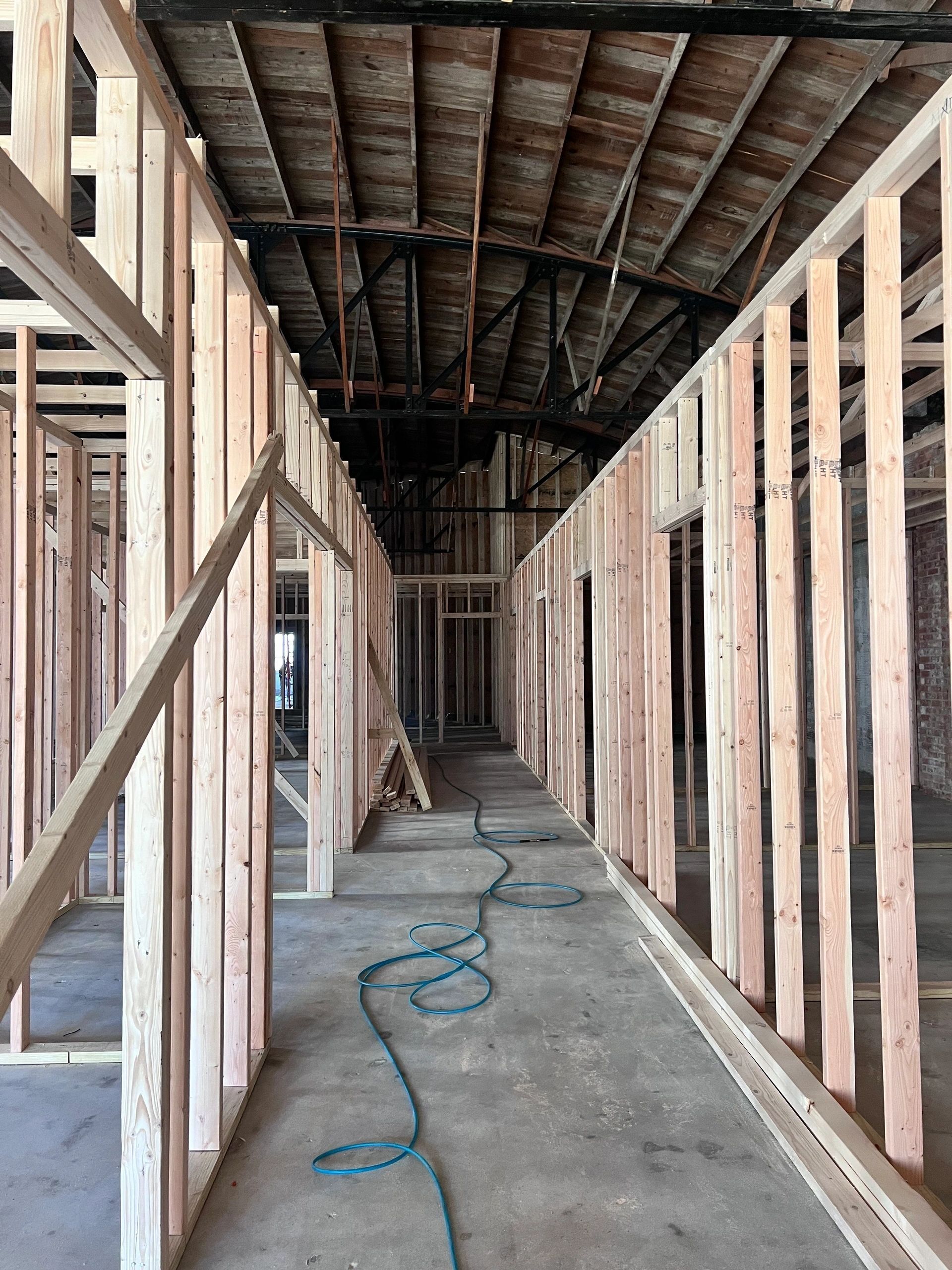 A building under construction with a blue hose in the middle