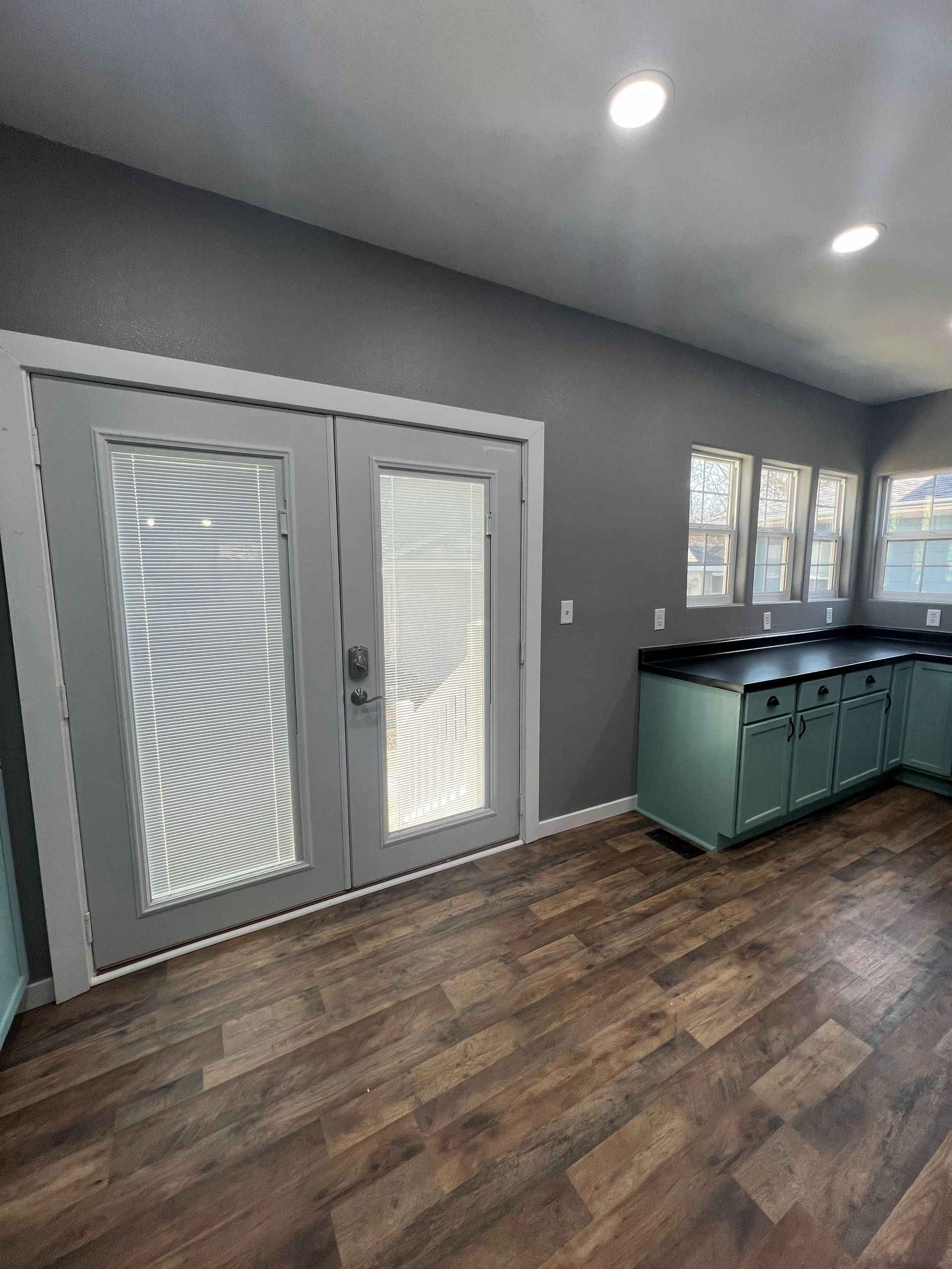 A kitchen with hardwood floors and gray walls