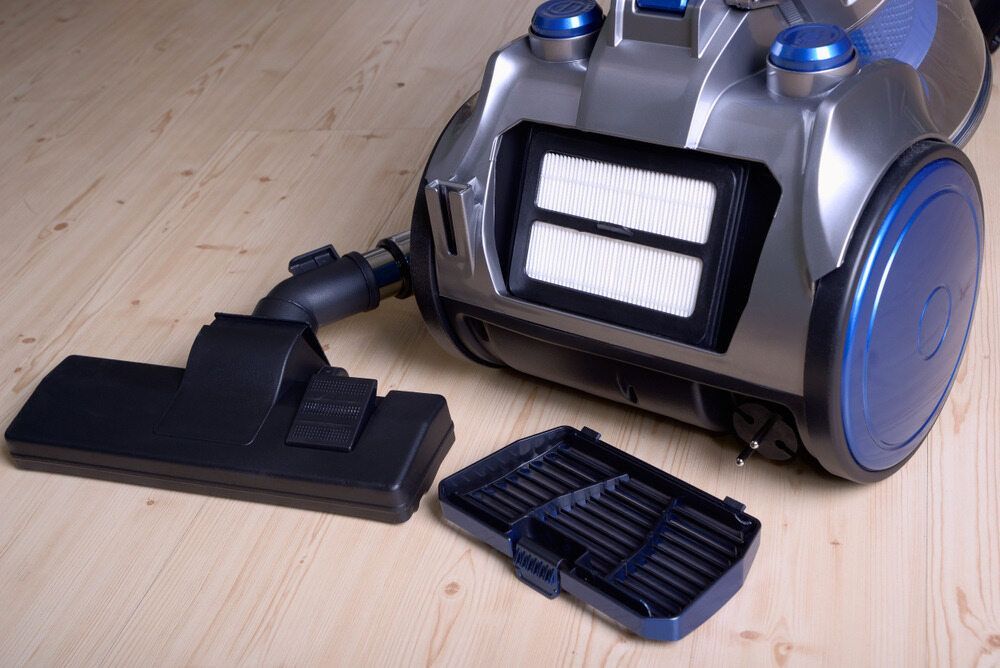 A Vacuum Cleaner With The Filter Removed Is Sitting On A Wooden Floor — Ken Matthews Auto & Mower Centre In Ulladulla, NSW