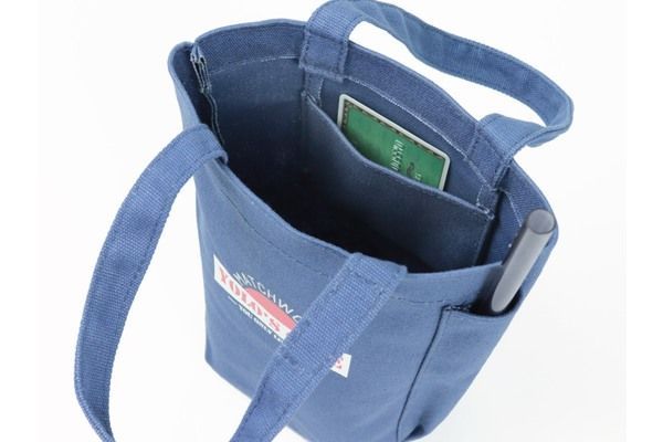 A blue tote bag with a pen in the pocket