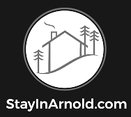 StayInArnold.com logo with a white house and pine trees in a circle on a black background