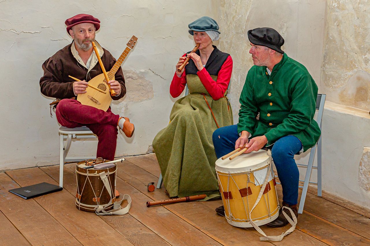A group of people are playing instruments in a room.