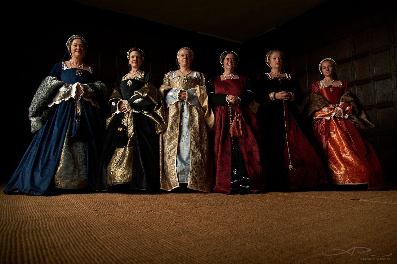 A group of women in medieval costumes are standing next to each other.