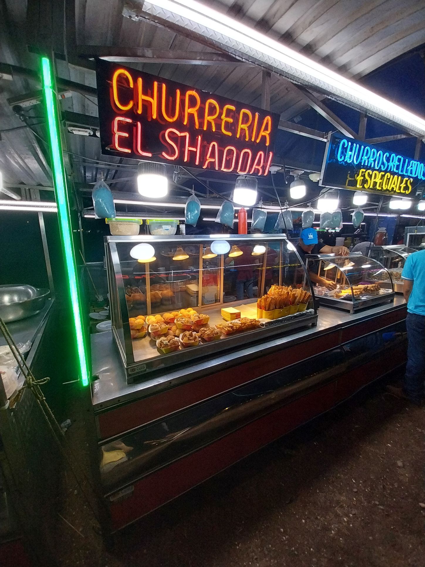 Food stand, Churrería El Shaddai, with pastries in glass display case.
