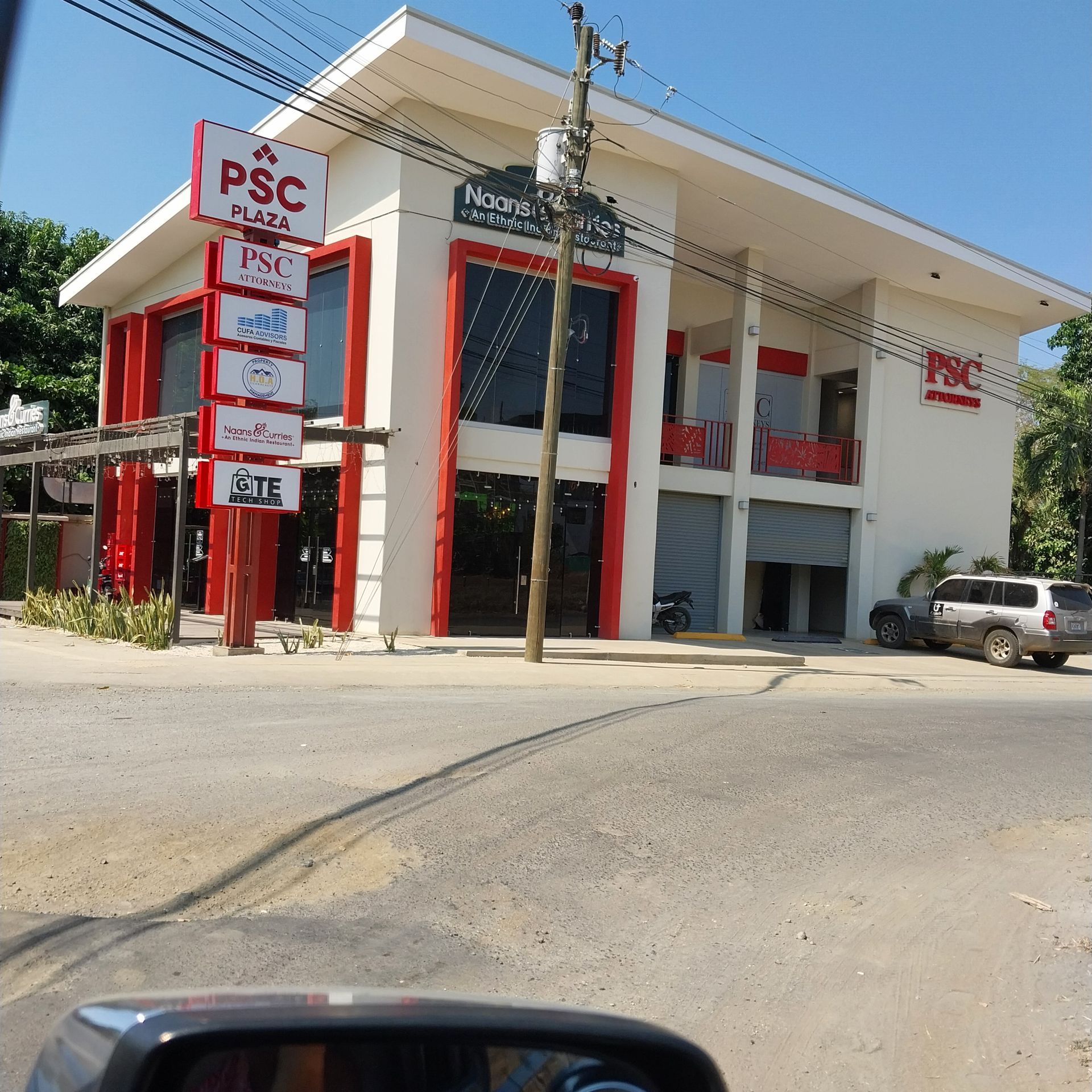 Two-story white building with red accents, 