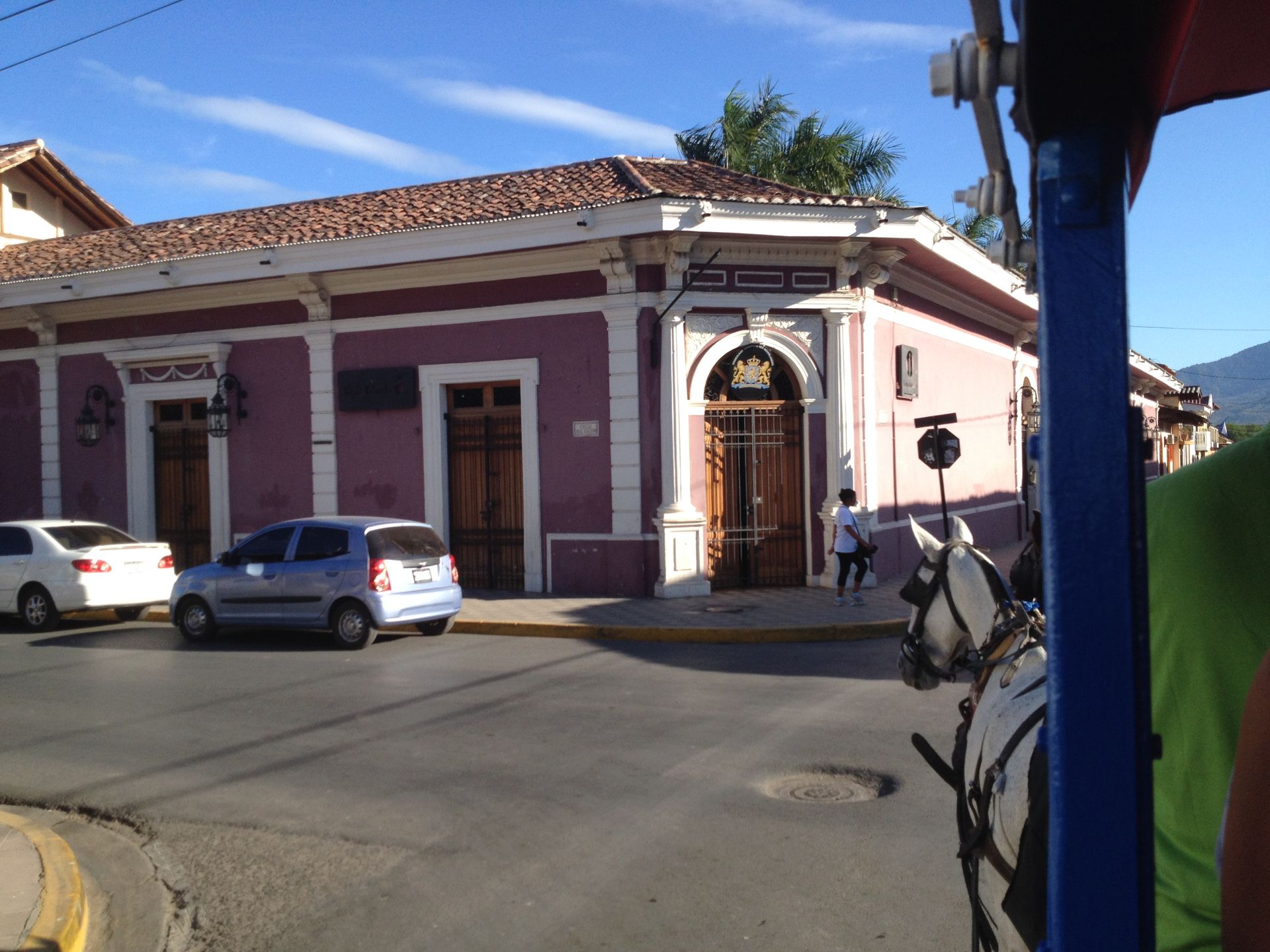 Purple building with white trim, cars on the street, and horse-drawn carriage.
