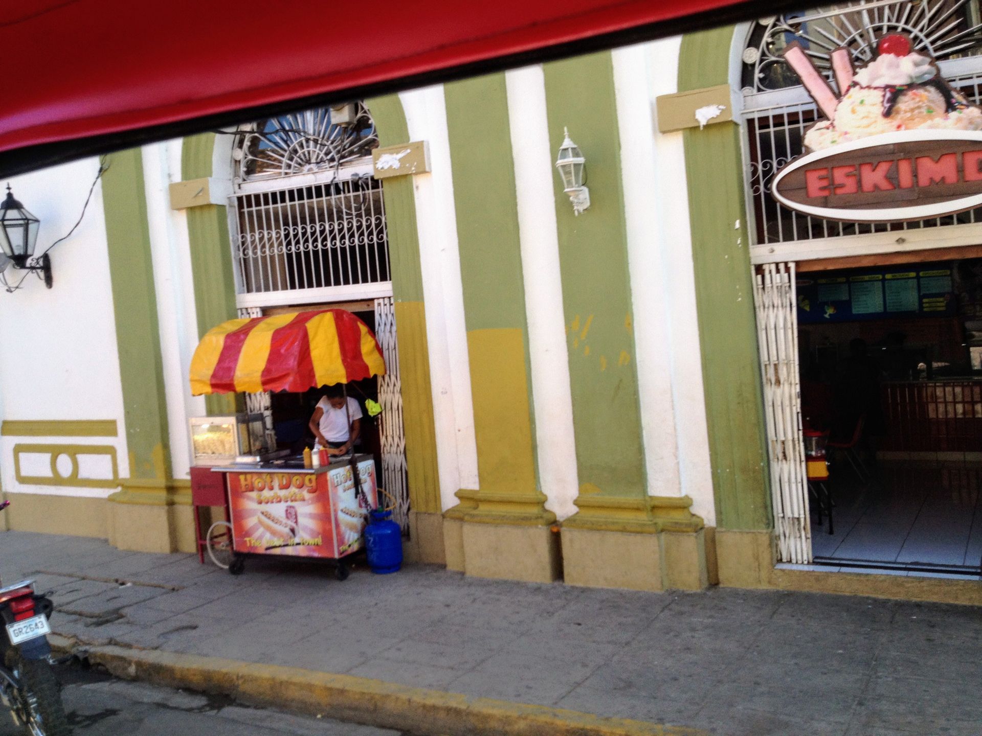 Ice cream shop with a striped facade, outdoor vendor, and 