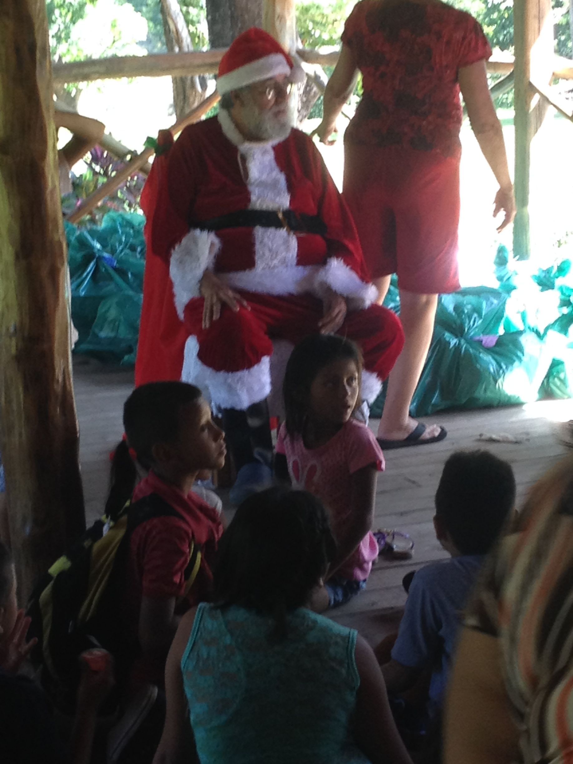 Santa Claus sits with children outdoors.