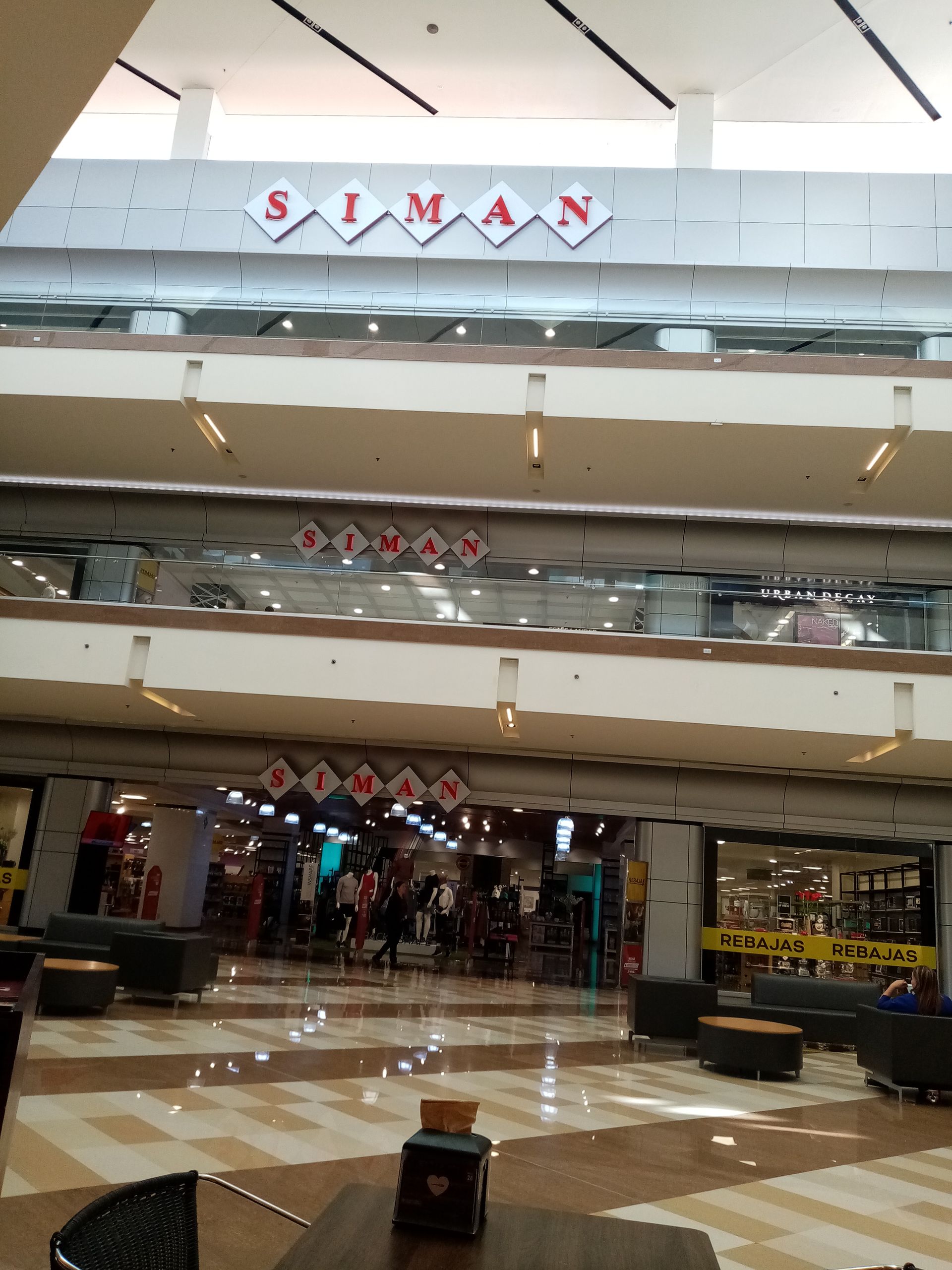 Interior of Siman department store with multiple levels and displays.
