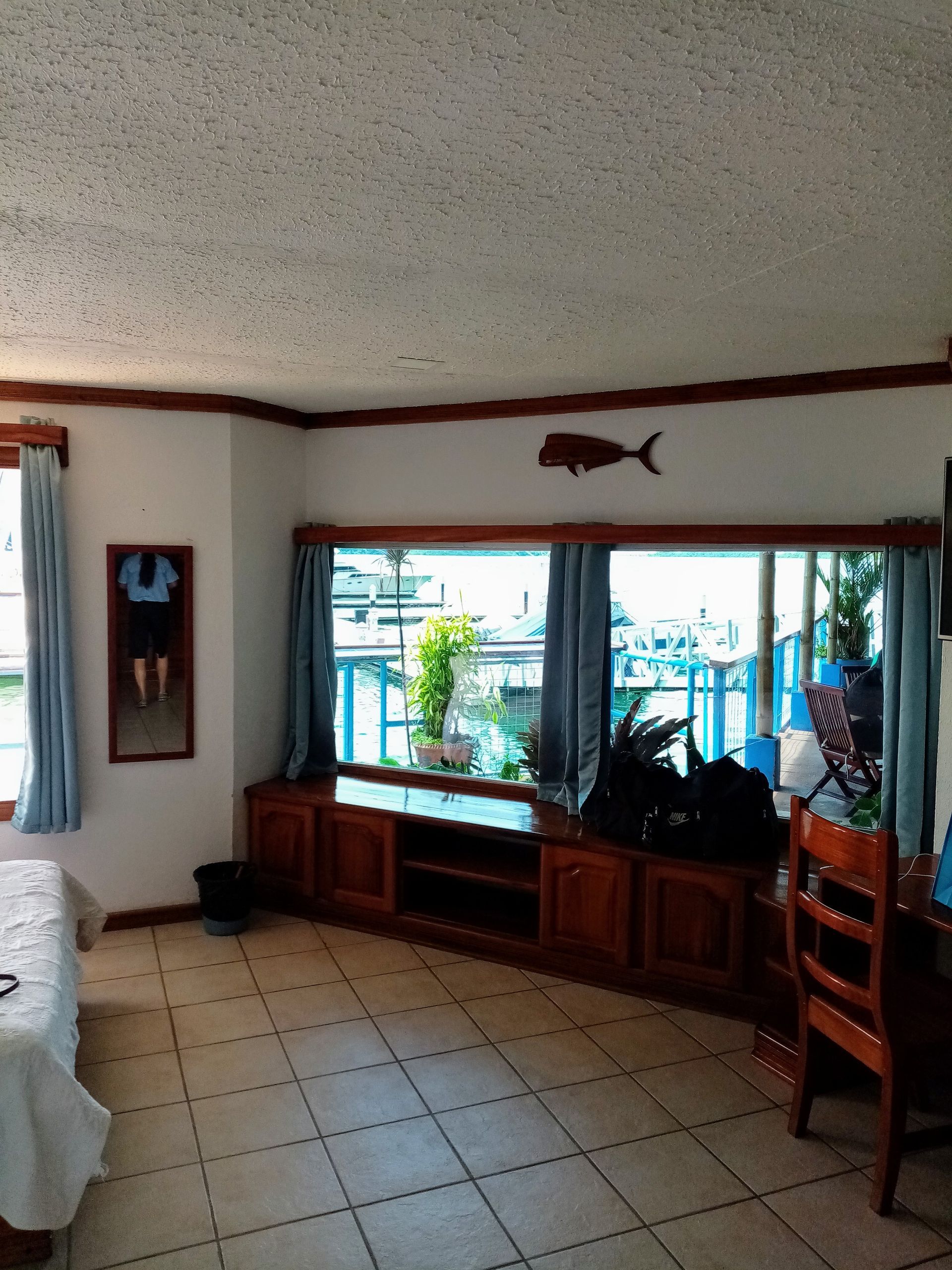 Interior room with a large window, wooden cabinets, and a decorative fish on the wall.