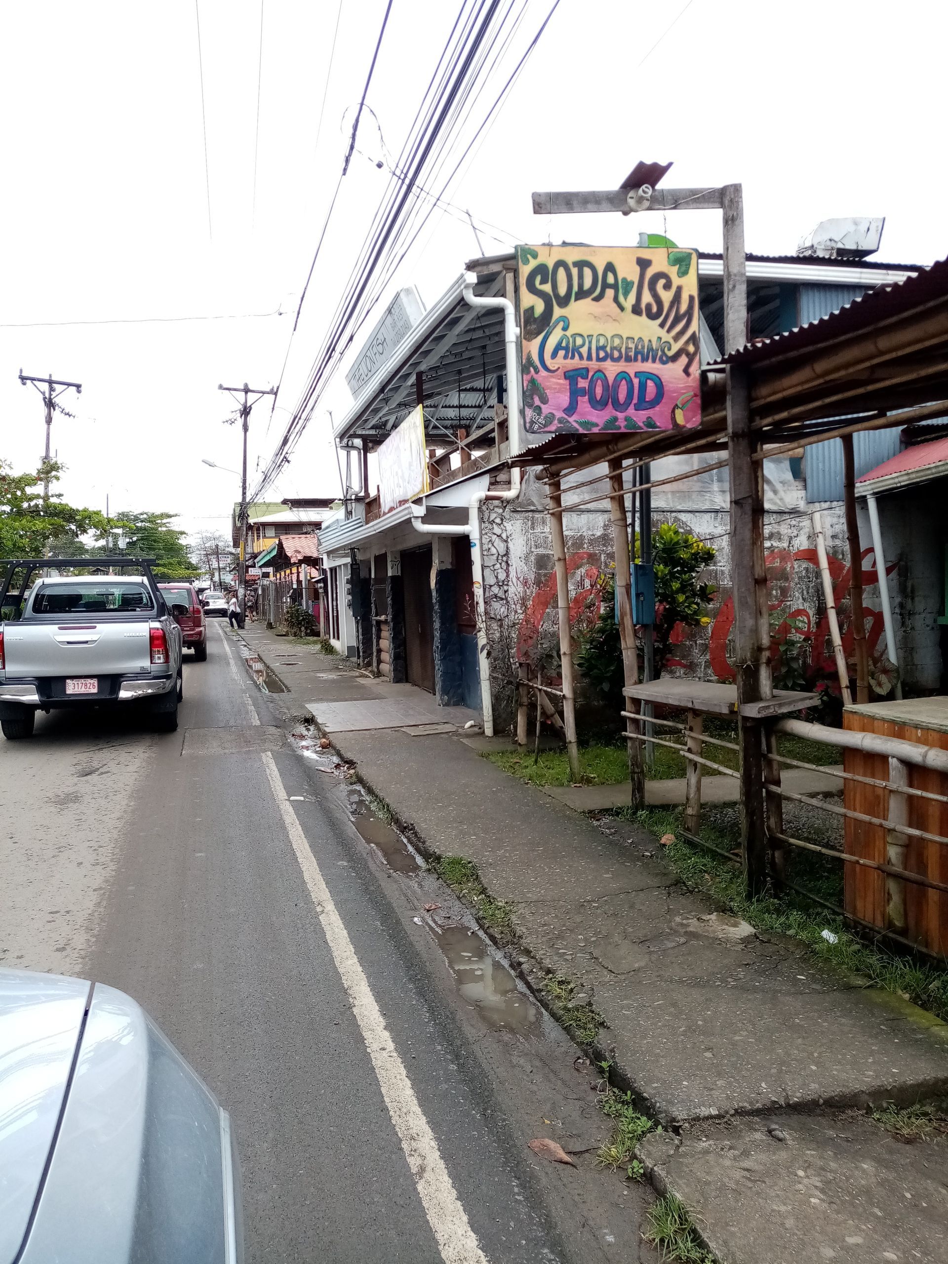 Street scene with cars, buildings, and a sign for 
