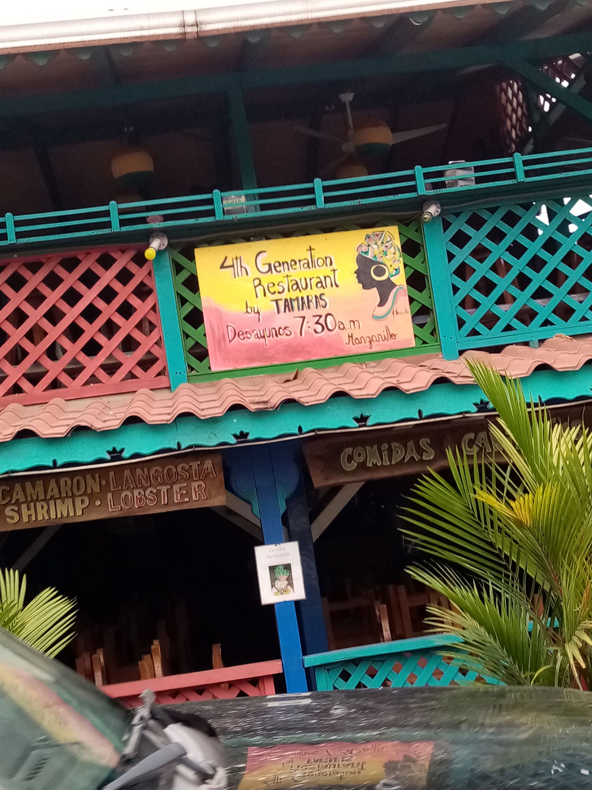 Colorful restaurant facade with sign, red, turquoise, and yellow accents. 