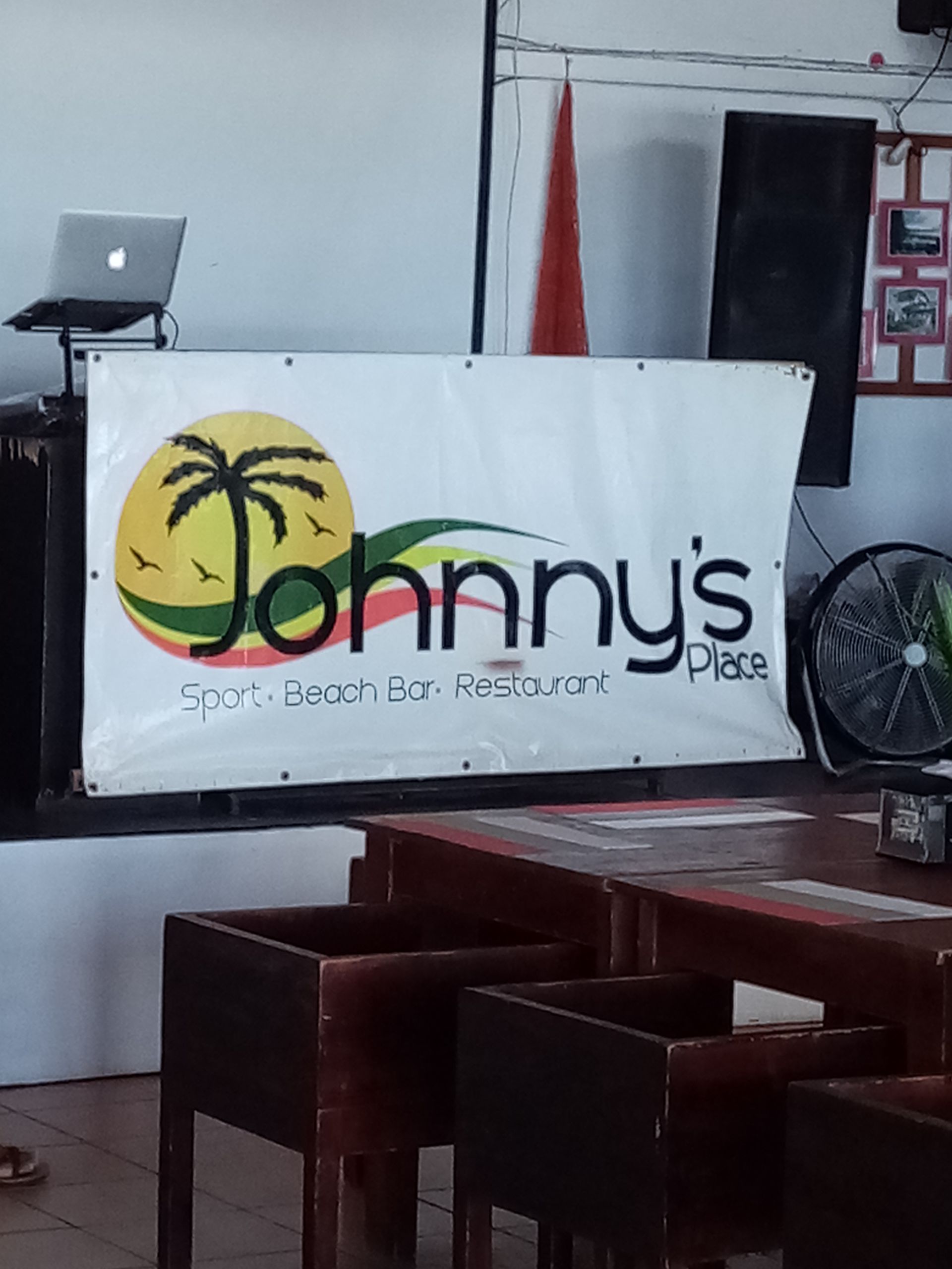Sign for Johnny's Place: sports bar and restaurant, with logo of a palm tree within a circle.