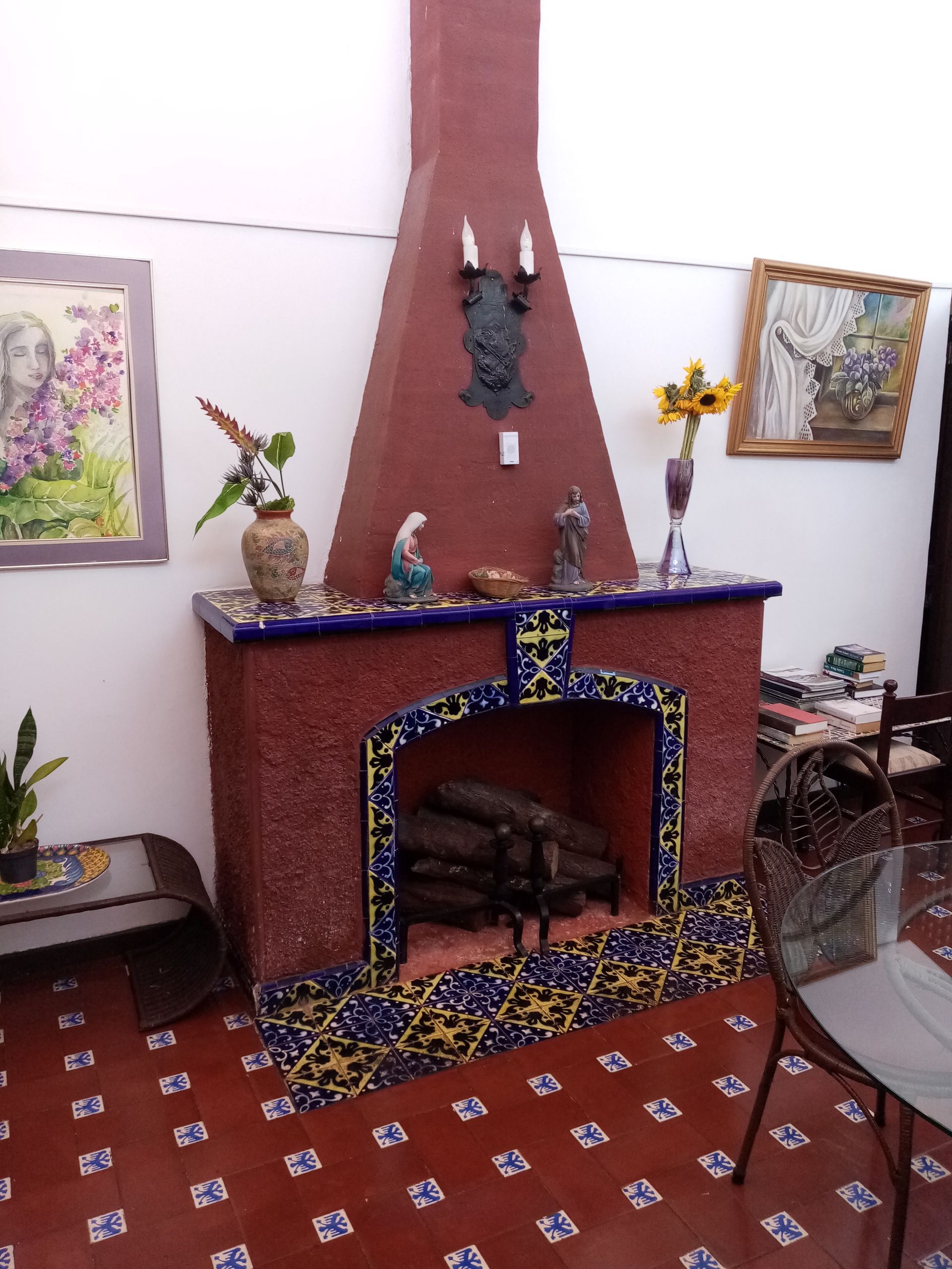 Brick fireplace with blue and yellow tile trim, red walls, and decorative items.