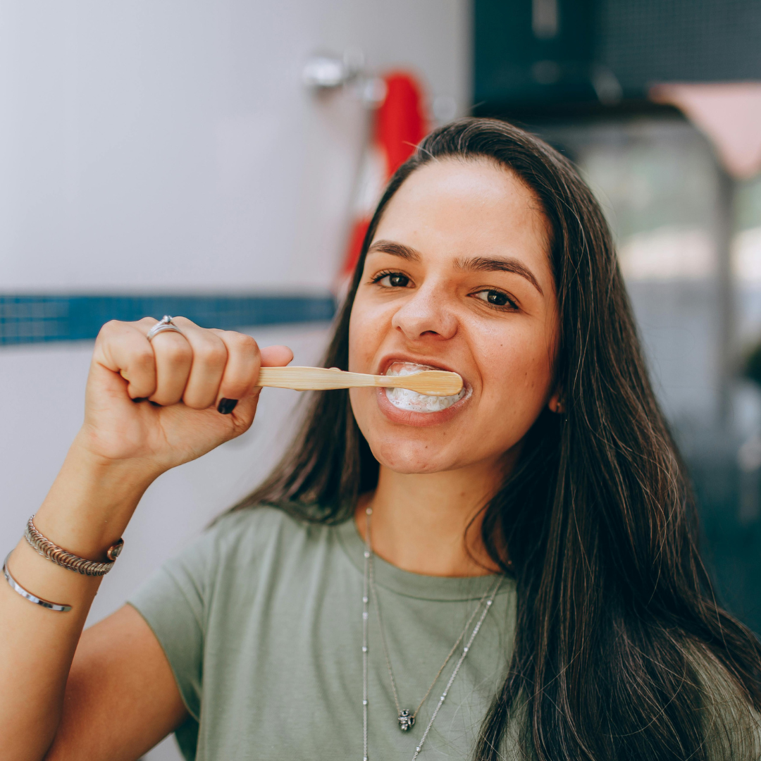 Woman brushing teeth in bathroom.
