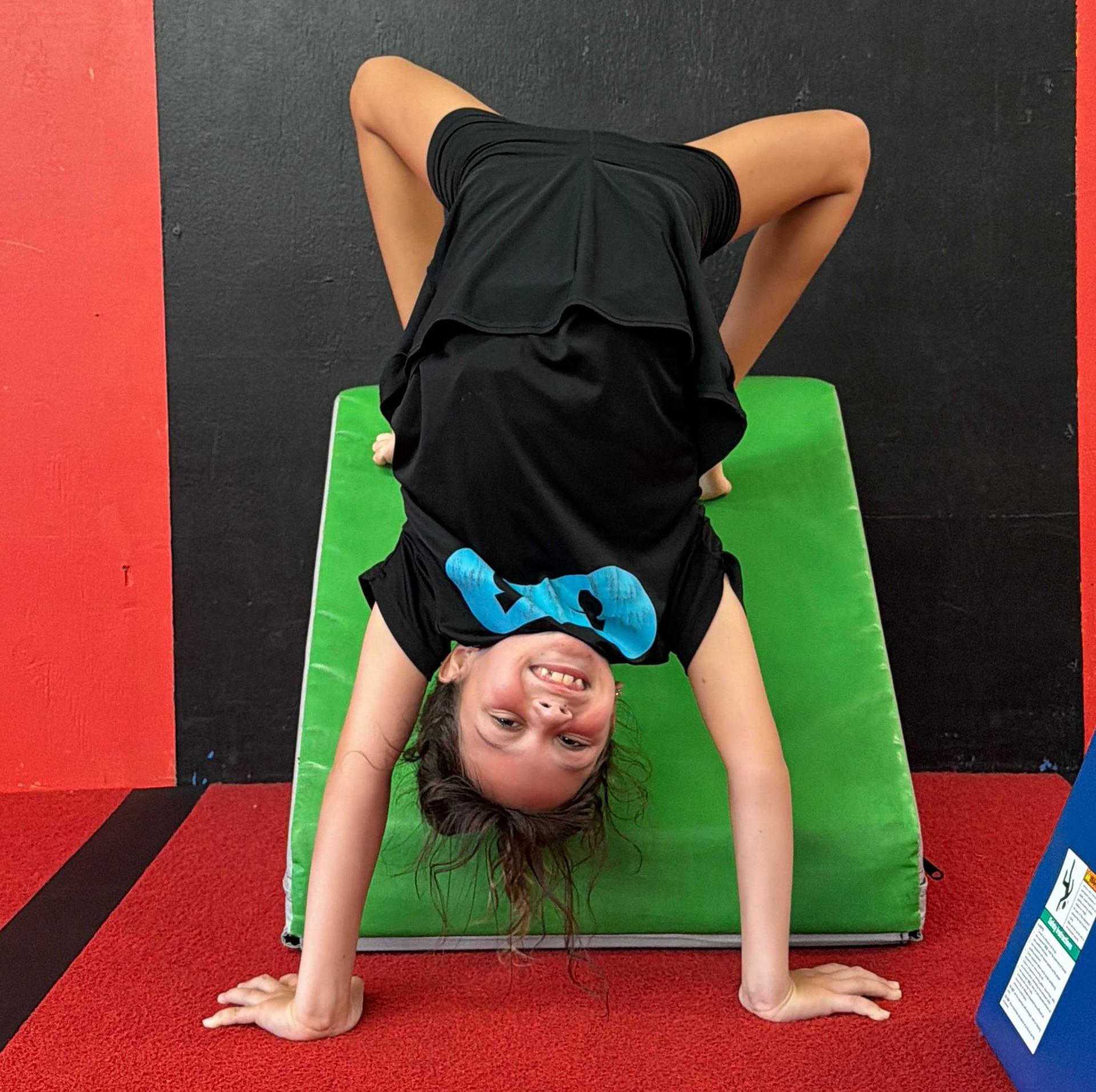 Coach supporting a child's growth and skill development at Gravity Gymnastics in Miramar.