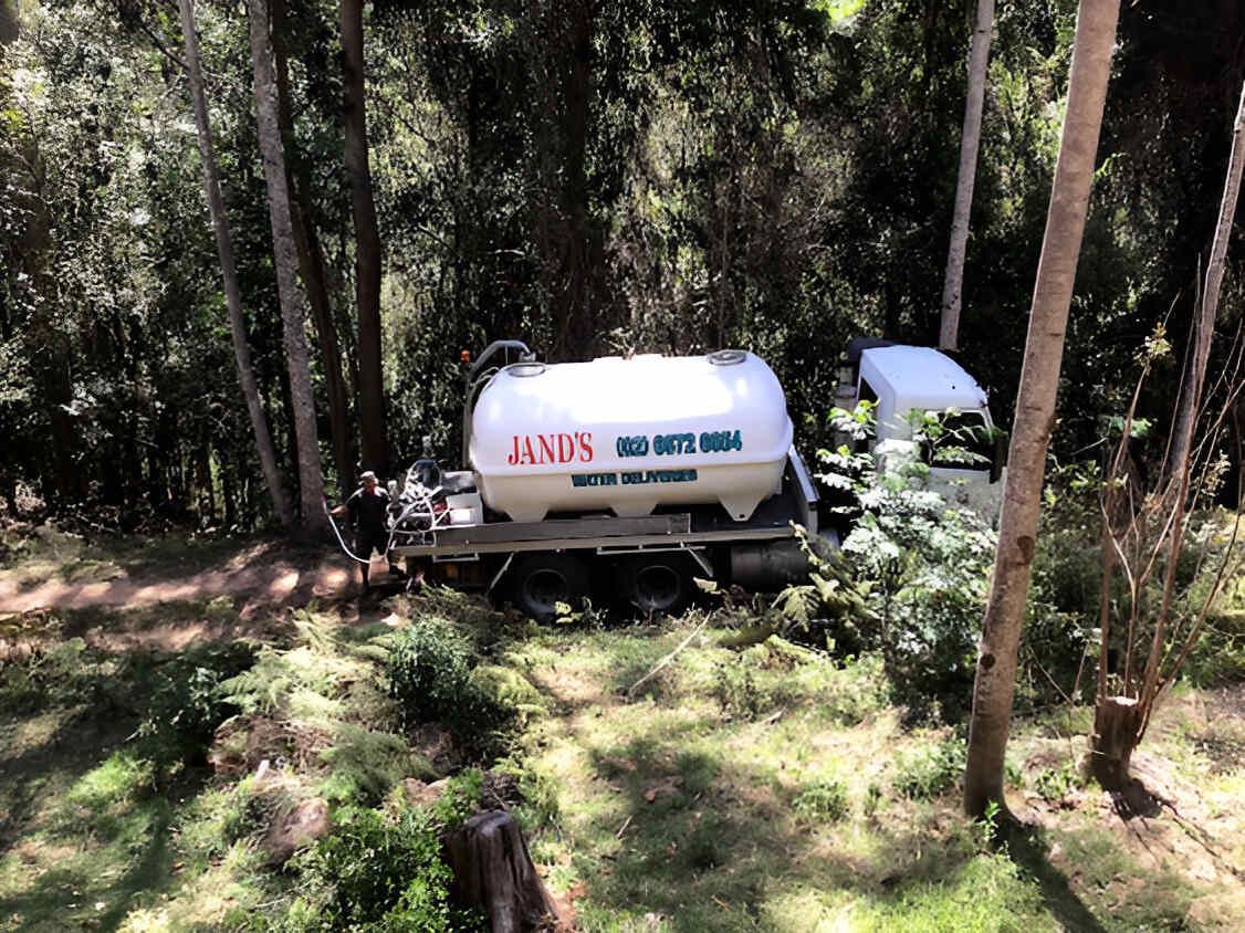 A Tanker Truck Is Parked In The Middle Of A Forest โ Glass~a~Water In Eungella, NSW
