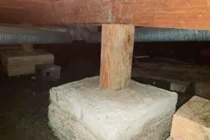 A wooden post is sitting on top of a concrete base.