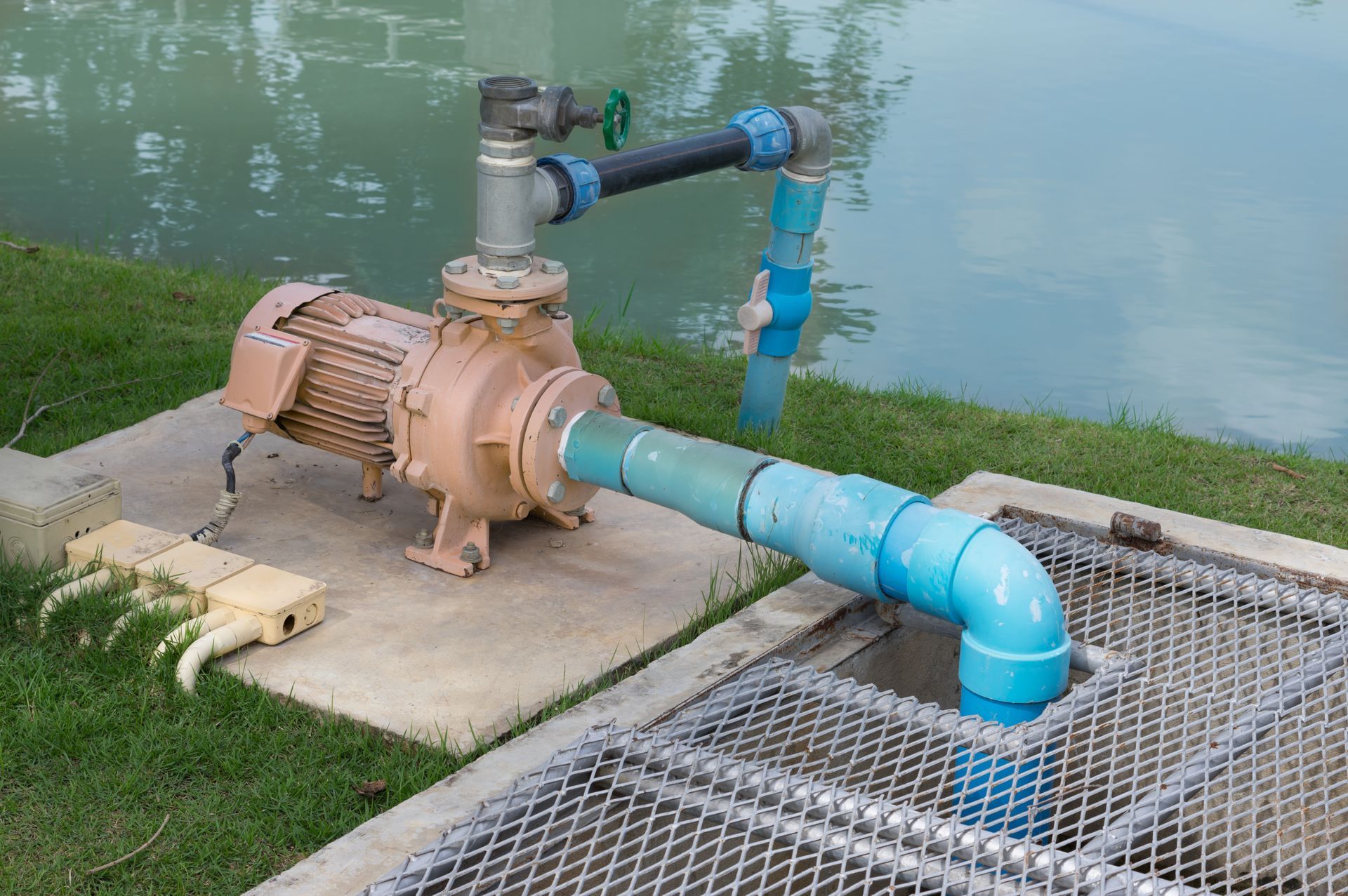 An electric water pump at a water’s edge. An electric water pump at a water’s edge.