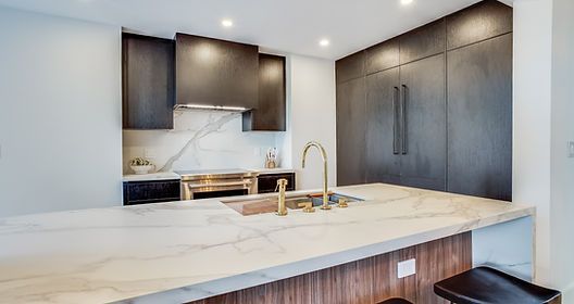 A kitchen with a sink , stove , refrigerator and cabinets.