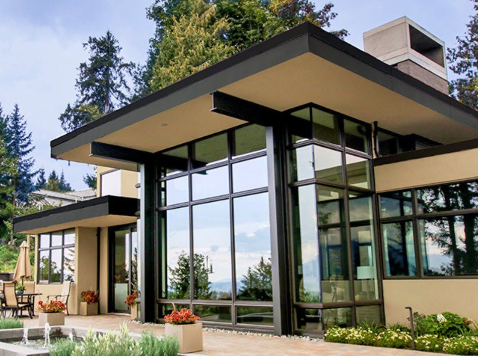 A large house with a lot of windows and trees in the background