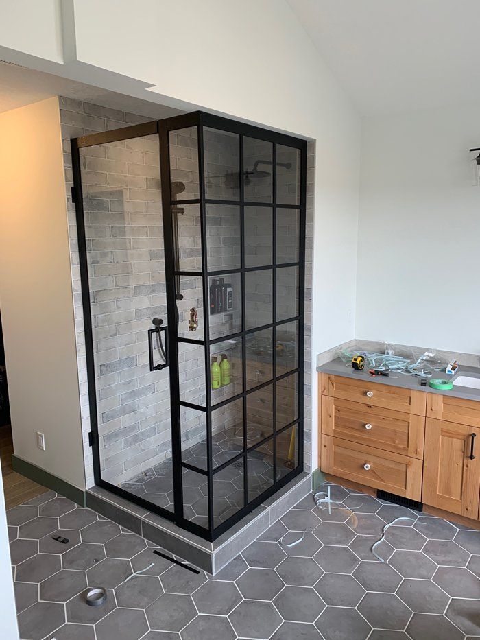 A bathroom with a walk in shower and a sink.
