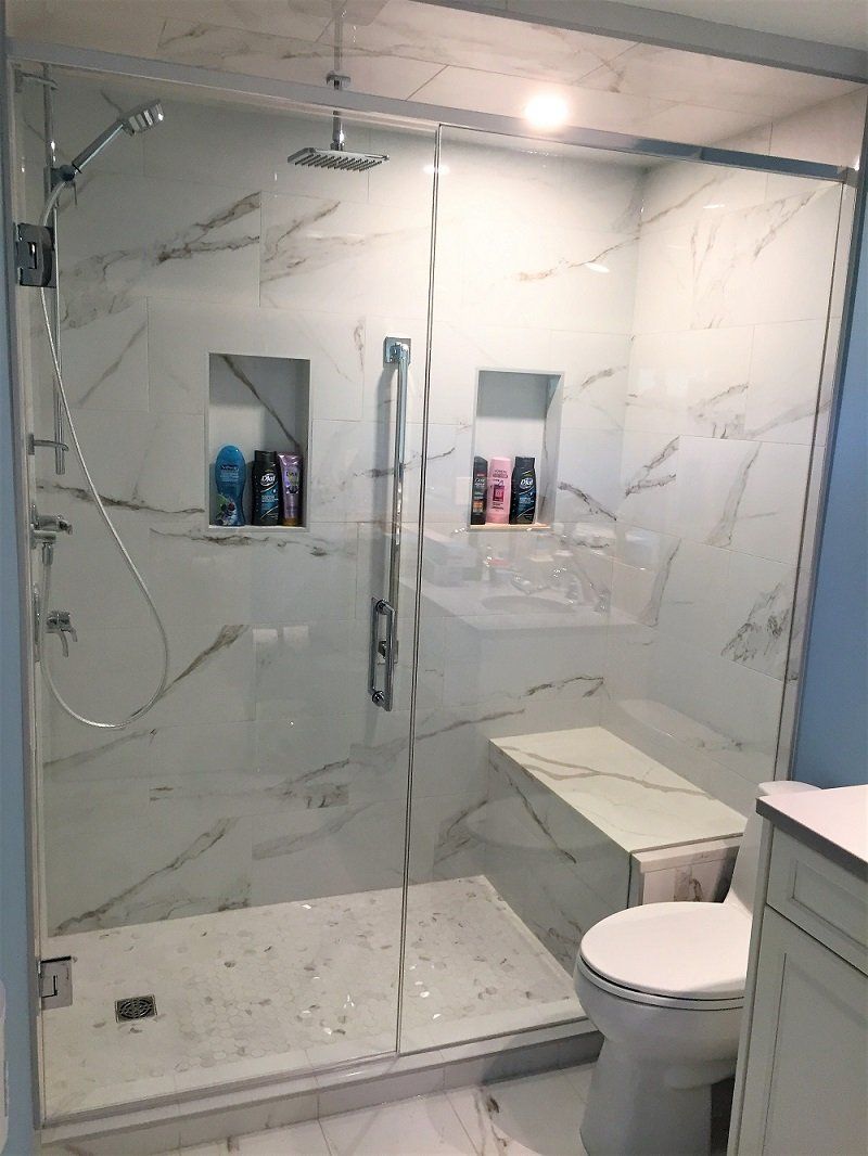 A bathroom with a walk in shower , toilet and sink.