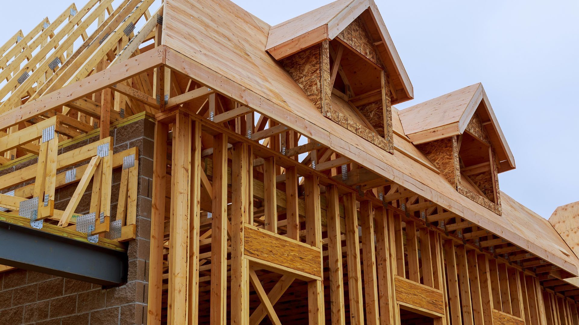 A house is being built with wooden beams and a roof.