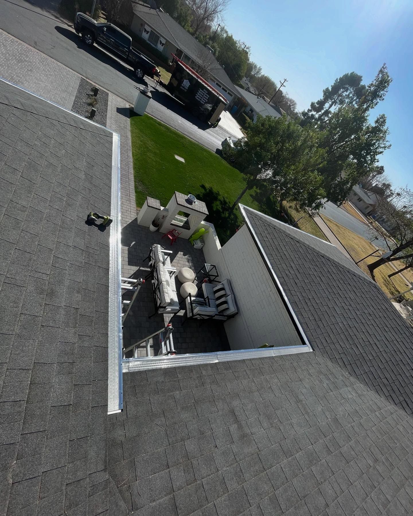 Roof-mounted HVAC equipment on a flat rooftop near a parking lot and trees.
