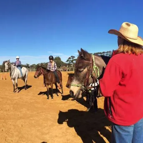 students on horses i the outdoor arena