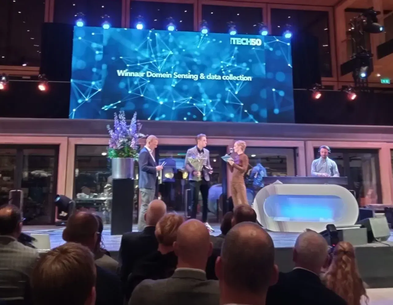 A group of people sitting in front of a large screen that says itcsb