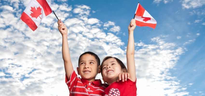 The siblings happily hold a Canadian flag to express gratitude for Canadian child benefits.