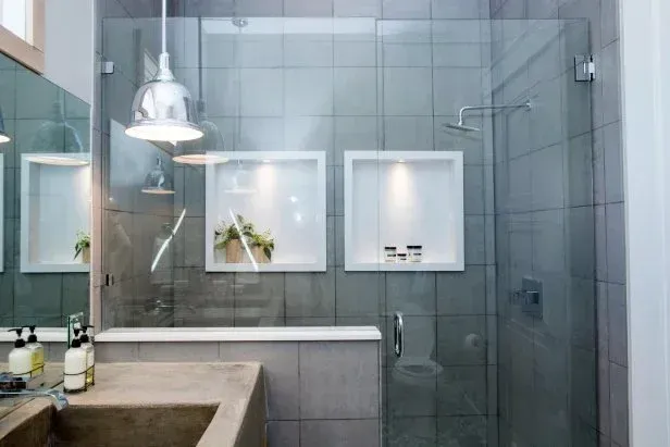A bathroom with a sink , shower , and mirror.