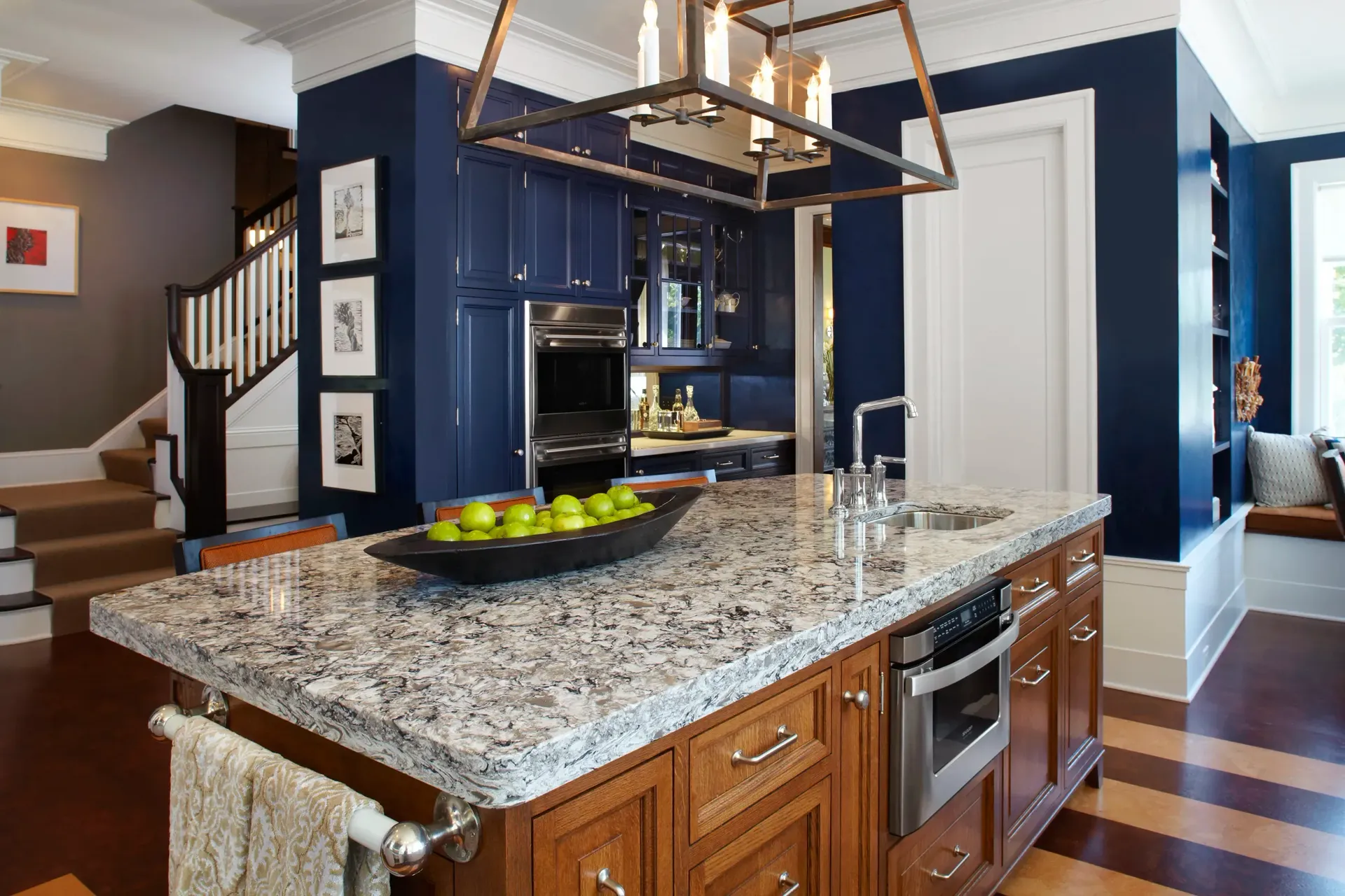 A kitchen with a granite countertop and wooden cabinets.