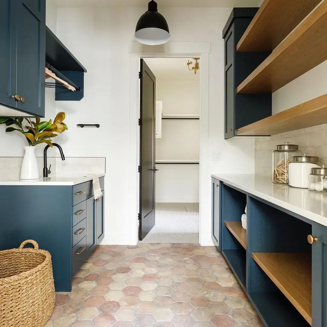A kitchen with blue cabinets and wooden shelves